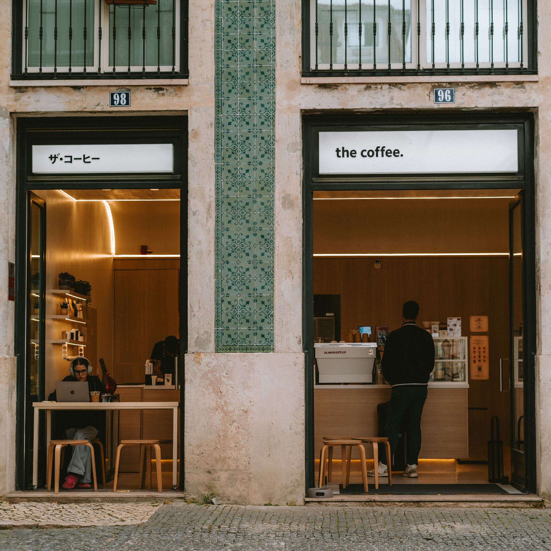Clientes no exterior de um café moderno em Lisboa, uma imagem dos negócios que estão por detrás dos dados portugueses sobre sites.