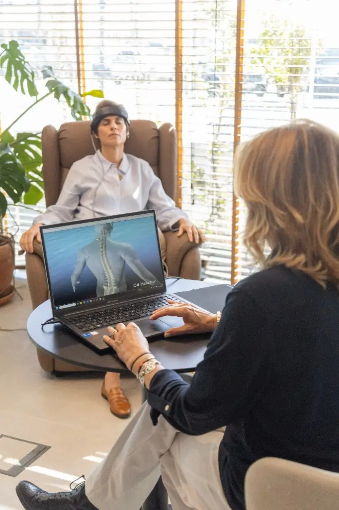 Sessão Biofeedback FPC em clínica com profissional, cliente e equipamento visíveis.